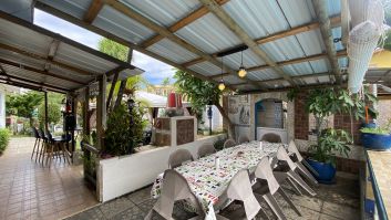 le coin repas sous la veranda avec un grand barbecue disponible.